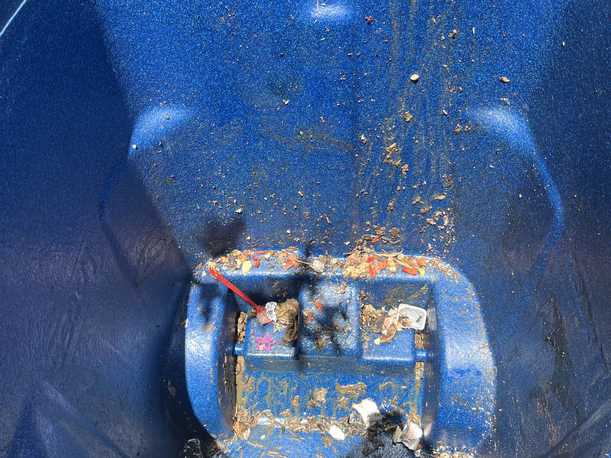 Trash bin interior caked with built-up grime and residue before cleaning